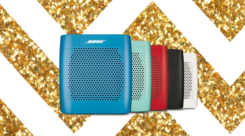 Colorful Bose Soundlink speakers are displayed in front of a gold sparkly background